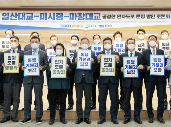 이재명 지사(앞줄 가운데)가 24일 서울시 여의도 소재 이룸센터에서 열린 ‘공정한 민자도로 운영을 위한 국회토론회’에 참석해 '통행기본권 보장' 패널을 들고 있다.(사진=경기도청)