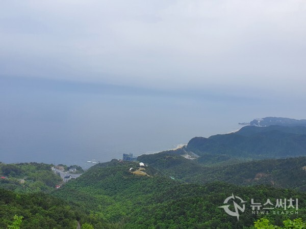 괘방산 산행 중 동해바다 풍경. 멀리 오른쪽으로 정동진 해변과 썬크루즈리조트가 보이고 가운데 ‘강릉통일동산’과 대포동 해변이 한눈에 조망된다.