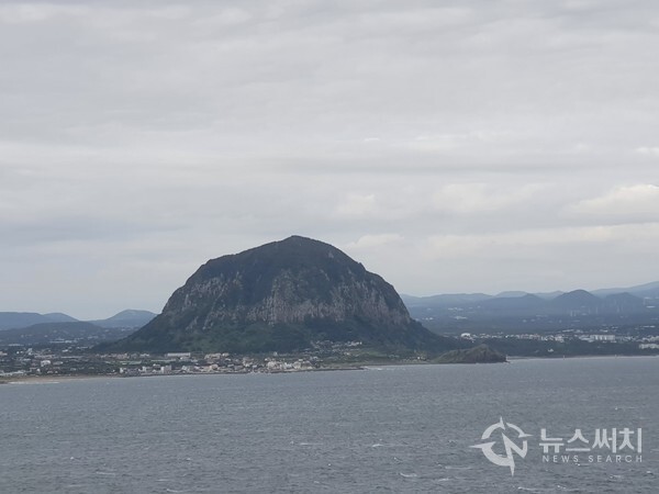 송악산에서 바라본 산방산. 송악산은 정상이 104m 높이로 그리 높지 않으나 바닷가 해변에 솟아 있어서 인근 경치를 한눈에 조망할 수 있는 최고의 전망장소이다. 송악산으로 오르는 둘레길을 걷다 보면 멀리 안덕면 사계리 해안에 종 모양으로 우뚝 솟아있는 ‘산방산’을 뚜렷이 볼 수 있다. 